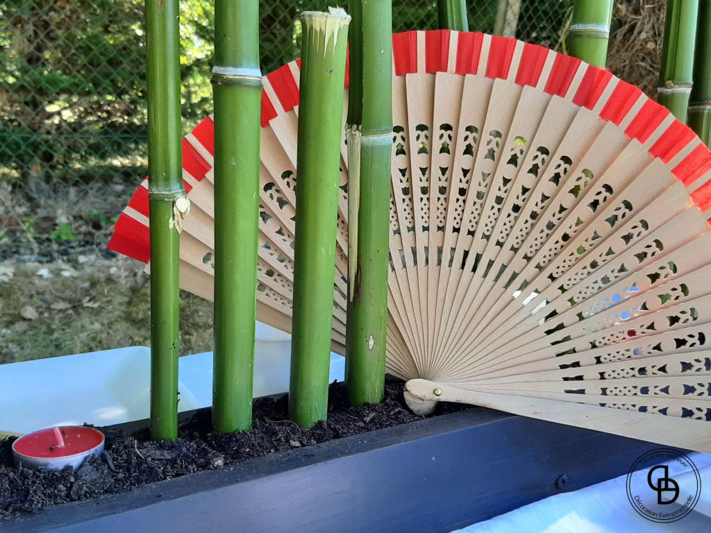 Détail de la décoration de table asiatique avec du bambou et un éventail rouge